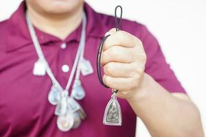 hombre sostiene Buda amuleto. concepto, fe y creencia de budista para santo a proteger desde peligros, traer bueno suerte, negocio prosperidad y poder. colectar amuleto como aficiones, intercambio, vender o comprar. foto