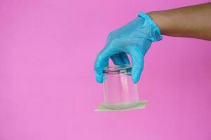 de cerca mano sostener y giro un vaso de agua terminado abajo. cubierto el vaso con papel. concepto, Ciencias experimentar acerca de aire y líquido presión. fácil Ciencias tema actividad, educación. foto