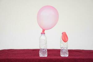 Science experiment , inflated balloons and flat balloon on top of transparent test bottles. Concept, science experiment about reaction of chemical substance, vinegar and baking soda. photo