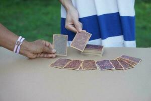 Close up hands choose and pick  up paper cards. concept, fortune reading. astrology. Foretelling, mystery, magic, fortune, fate. Prediction for future life ,events. photo