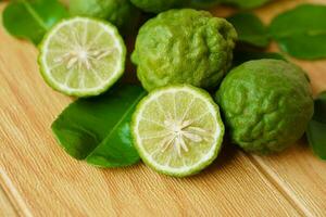 Bergamot fruits and leaves on  wooden background. Concept, herbal fruits with sour taste, can be cooked as food seasoning and use for spa , aroma photo