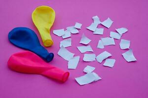 Colorful balloons and small pieces of paper on pink background. Concept Science project work activity.Fun and easy experiment about static electricity. photo