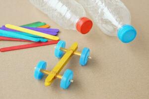 Handmade toy racing car made from ice cream sticks and bottle caps. Concept, Recycling kids toy. Easy to do, creative DIY craft that kids can do. Recycle invention. photo