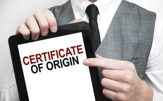 Businessman showing business concept on tablet standing in office CERTIFICATE OF ORIGIN photo