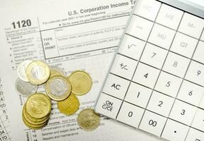 coins with calculator and tax form on white background photo