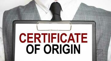 Businessman holding sheet of paper with a message CERTIFICATE OF ORIGIN photo