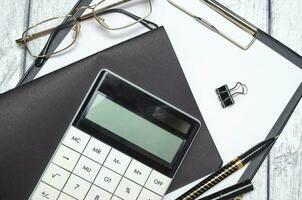 Financial charts, graphs, pen with round glasses and calculator. photo