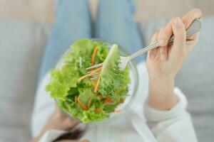 dieta y haciendo dieta, disfrutar comer. sano mujer sostener ensalada comida y sensación contento. belleza Delgado hembra cuerpo logra peso pérdida objetivo para sano vida, loco acerca de delgadez, Delgado cintura, nutricionista. foto