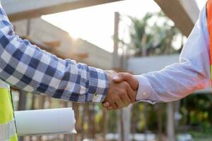 Construction worker team hands shaking greeting start up plan new project contract in office center at construction site, industry ,architecture, partner, teamwork, agreement, property, contacts. photo