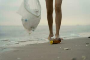 salvar océano. voluntario recoger arriba basura basura a el playa y el plastico botellas son difícil descomponer evitar daño acuático vida. tierra, ambiente, verdeado planeta, reducir global calentamiento, salvar mundo foto