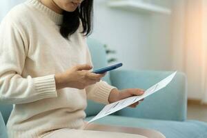 woman use phone scan barcode or QR codes to pay credit card bill after receiving document invoice. payment, receive, paying electricity, digital payments, technology, scanning, financial transactions photo