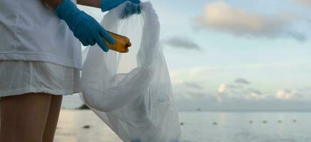 Save water. Volunteer pick up trash garbage at the beach and plastic bottles are difficult decompose prevent harm aquatic life. Earth, Environment, Greening planet, reduce global warming, Save world photo