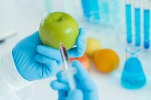 científico cheque químico comida residuos en laboratorio. controlar expertos inspeccionar calidad de fruta, científicos inyectar productos quimicos dentro manzanas para experimentos, peligros, prohibido sustancia, contaminar foto