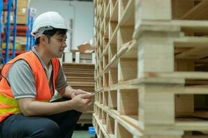 Asian male factory inspect pallet in warehouse or inventory and check stock product. Transport logistic business shipping, delivery to customers. inspection, storehouse, storage, factory photo
