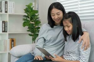 Technology searching on new education by use tablet at home. play back online course, girl student use internet to study, notes homework, world wide. online tutor online course for Asian children. photo