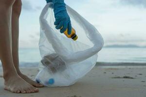 Save water. Volunteer pick up trash garbage at the beach and plastic bottles are difficult decompose prevent harm aquatic life. Earth, Environment, Greening planet, reduce global warming, Save world photo