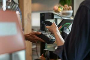 Woman use smartphone to scan QR code to pay in cafe restaurant with a digital payment without cash. Choose menu and order accumulate discount. E wallet, technology, pay online, credit card, bank app. photo