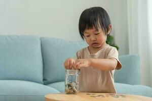 ahorrar dinero. niños poniendo monedas para ahorrar. riqueza, finanzas, seguros, inversiones, educación, futuro, planificar la vida, aprender, banca, familia, salud, salud y seguros de accidentes. foto