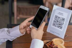 use smartphone to scan QR code for order menu in cafe restaurant with a digital delivery. Choose menu and order accumulate discount. E wallet, technology, pay online, credit card, bank app. photo