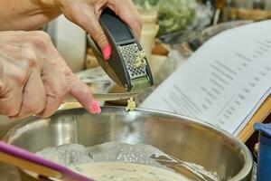 Chef tosses the garlic from the garlic press into the dish photo