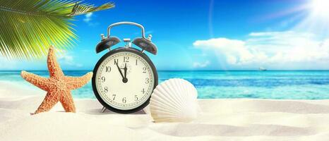 Alarm clock on tropical beach - summer holiday. photo