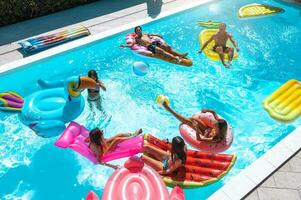 amigos en traje de baño en el piscina consiguiendo un bronceado foto