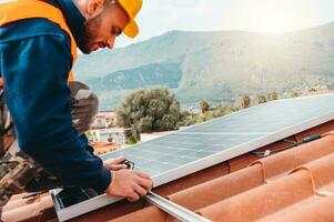 Workers assemble energy system with solar panel for electricity and hot water photo