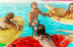 amigos en traje de baño en el piscina consiguiendo un bronceado foto