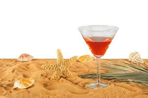 Fresh cocktail in a golden beach with seashells and starfish photo