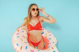 Amazed woman with an inflatable donut ready for the summer photo