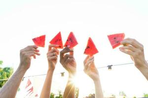 Group of friends eat fresh watermelon together photo