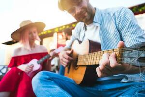 Friends have a picnic and play with guitar photo