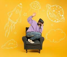 Boy with VR glasses play with a virtual videogame. Yellow background photo