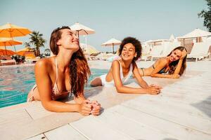 Group of friends in swimsuit enjoy in a swimming pool photo