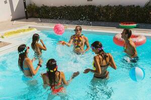 grupo de amigo jugar juntos en el nadando piscina foto