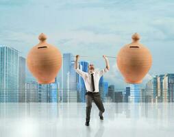 Powerful and determined businessman trains with a barbell with piggy banks photo