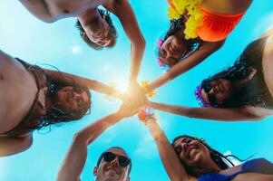 Happy smiling friends high five each other at the swimmingpool photo