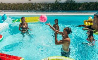 grupo de amigo jugar juntos en el nadando piscina foto