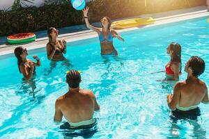 grupo de amigo jugar juntos en el nadando piscina foto