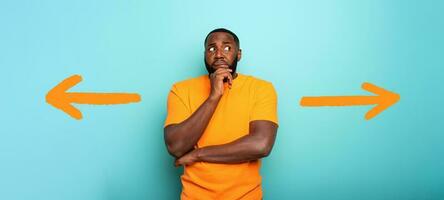 Confuse and pensive expression of a boy with right or left to choose. cyan colored background photo