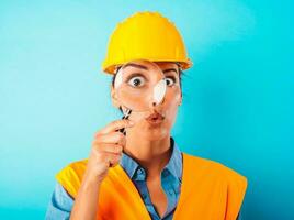 Amazed woman worker with helmet and magnifier photo