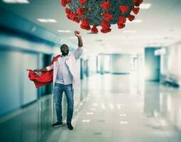 Super hero doctor with red cloak fights against a big virus photo