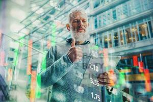 Businessman works with trading stock market chart on a tablet photo