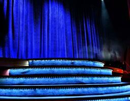 Elegant theater stage with closed blue curtain photo