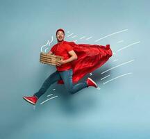 Deliveryman with pizzas acts like a powerful superhero. Concept of success and guarantee on shipment. Studio cyan background photo