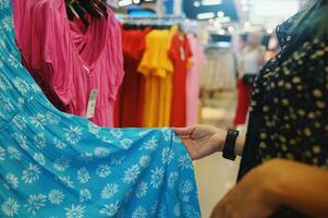 Woman selects a woman dress in a store photo