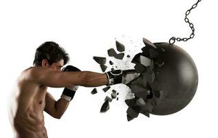 Power and determination of a young muscular boxer against a wrecking ball photo