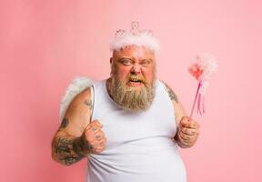 Fat angry man with tattoos acts like a magical fairy photo