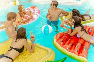 Friends in swimsuit in the pool getting a tan photo