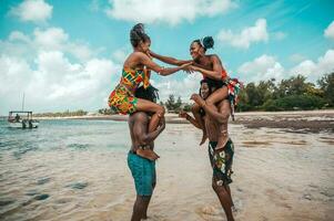 Kenia personas jugar en el playa con típico local ropa foto